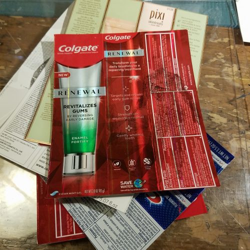 a stack of flattened packages from toothpaste and beauty supplies.