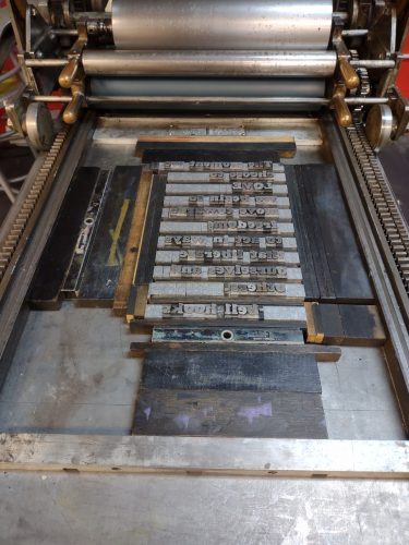 lead type set into a vandercook, ready for printing